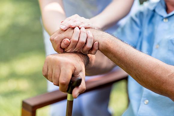 Home care in London. Domiciliary care services. Younique Care. Palliative Care. Senior man hand